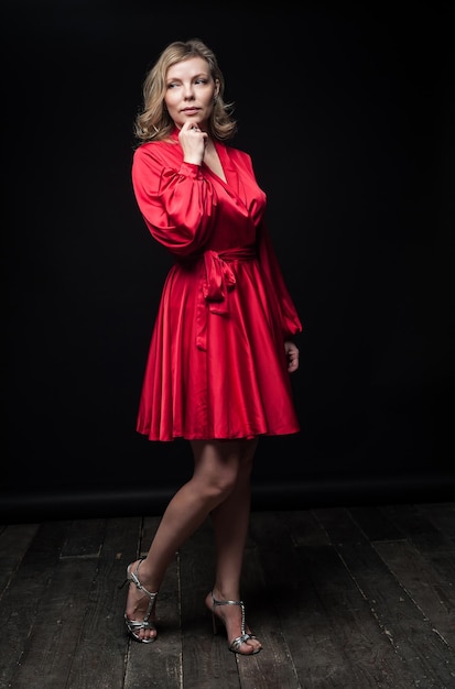 Blonde sexy en robe rouge en studio