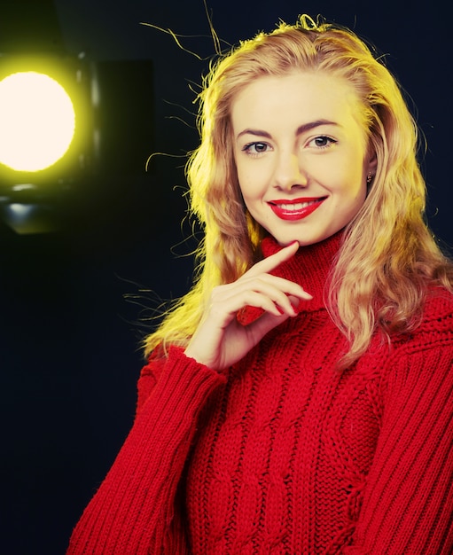 blonde souriante en pull rouge