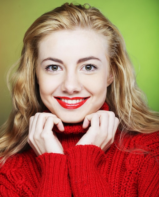 blonde souriante en pull rouge