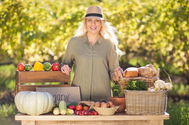 Blonde souriante sur une table de nourriture biologique