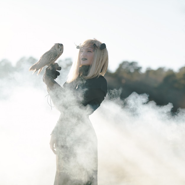 Blondie jeune mannequin pose avec le hibou