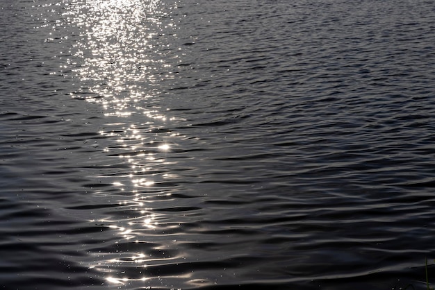 Éblouissement de la lumière du soleil sur la surface de l'eau du lac