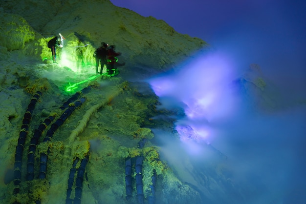 Photo blue flame dans une mine de soufre la nuit, volcan kawah ijen, java oriental, indonésien.