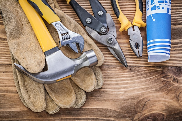 Blueprint gants de sécurité marteau à griffes pinces de préhension coupeur en acier clé à molette sur planche de bois.