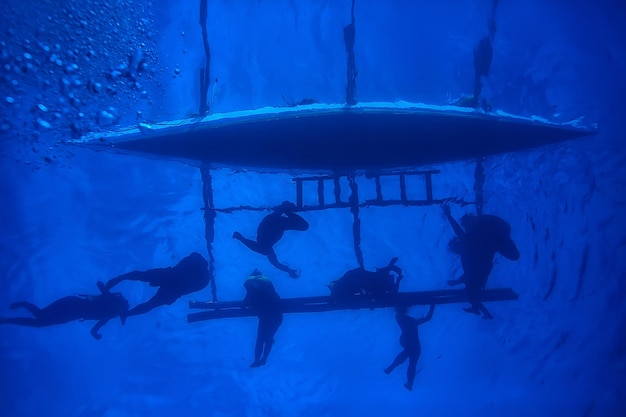 les boat people plongent sous l'eau / vue abstraite, paysage sous-marin, bateau et snorkeling