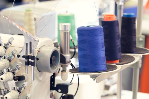 Photo bobines de fil bleu de fil textile à la machine de fabrication de tissage industriel