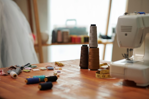 Bobines de fil et morceaux de tissu sur le bureau en studio d'artisan