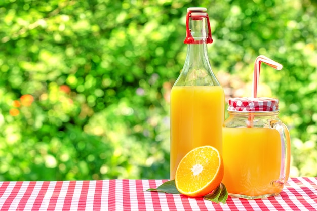 Bocal en verre et une bouteille de jus d'orange