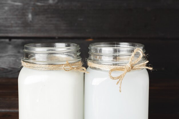 Photo bocal en verre de lait de coco bouchent sur une table en bois