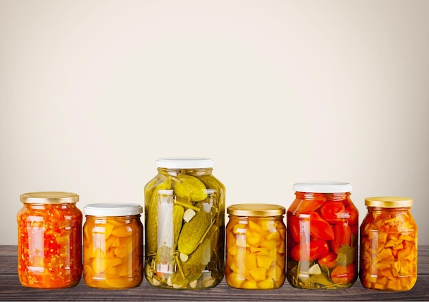 Bocaux avec des légumes en conserve sur fond de bois