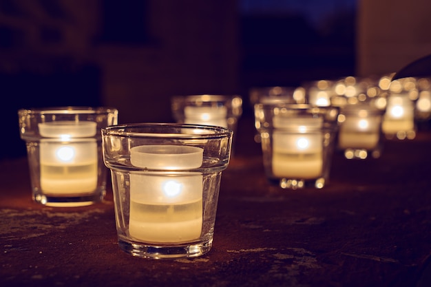 Bocaux en verre avec des bougies allumées dans le noir