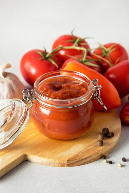 Bocaux en verre avec légumes en conserve lecho sur plateau en bois fond gris nourriture en conserve maison