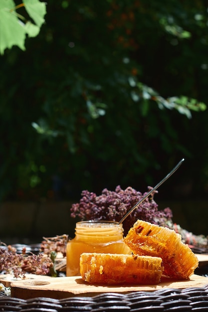 Photo bocaux en verre de miel contre les feuilles vertes, un concept de petit-déjeuner sain