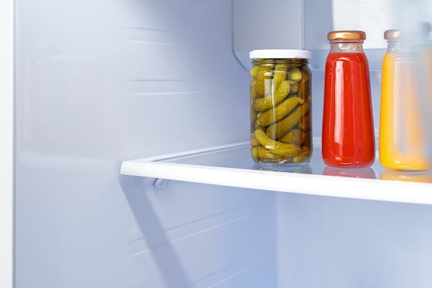 Bocaux en verre de produits en conserve sur une étagère de réfrigérateur close up