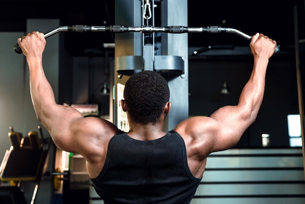 Bodybuilder athlète masculin travaillant dans la salle de gym