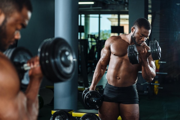 Bodybuilder athlète masculin travaillant dans la salle de gym