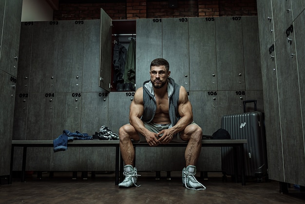 Le bodybuilder est fatigué dans les vestiaires après avoir terminé la formation