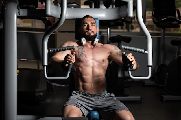 Bodybuilder faisant de l'exercice sur la poitrine de la machine