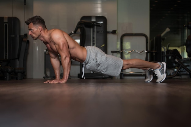 Bodybuilder faisant des pompes sur le sol