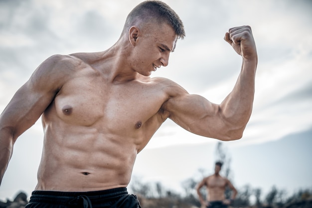 Bodybuilder fort brutal posant en plein air. Séance photo dans une carrière. Concept de sports de plein air.