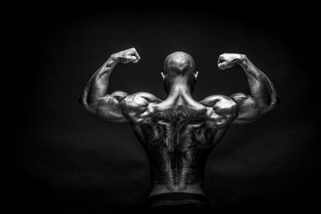 Photo bodybuilder fort posant et montrant les muscles