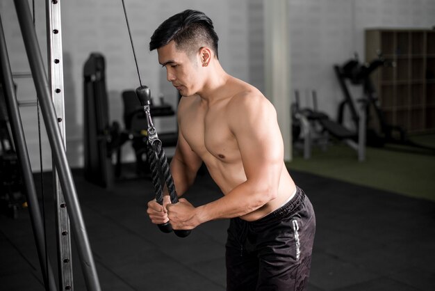 Bodybuilder homme fitness musculaire est séance d'entraînement dans la salle de gym