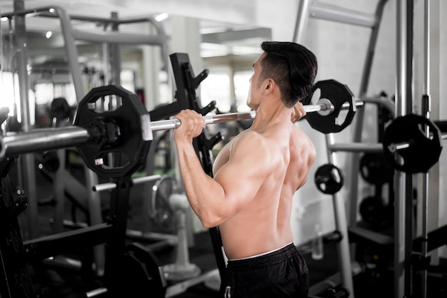 Bodybuilder homme fitness musculaire est séance d'entraînement dans la salle de gym