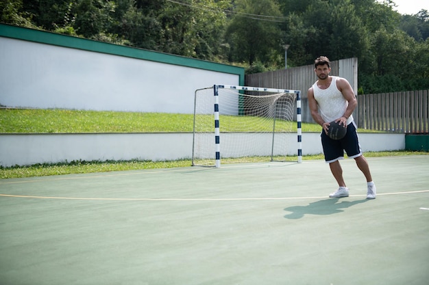 Bodybuilder jouant au basket en plein air