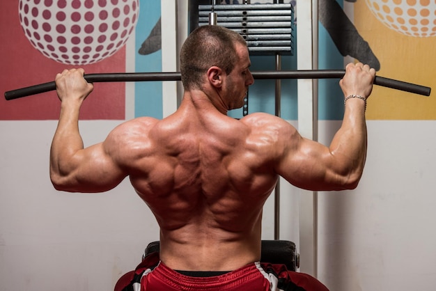 Photo bodybuilder masculin faisant des exercices de poids lourds pour le dos