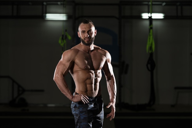 Bodybuilder musclé montrant ses abdominaux avant