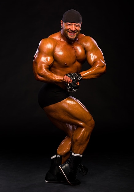Photo bodybuilder musculaire en short noir et bandana posant