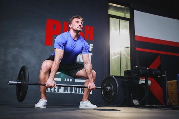 Bodybuilder musculation avec des haltères dans le concept de musculation d'entraînement des muscles de la salle de gym