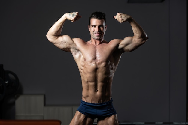 Bodybuilder Performing Front Double Biceps Pose In Gym