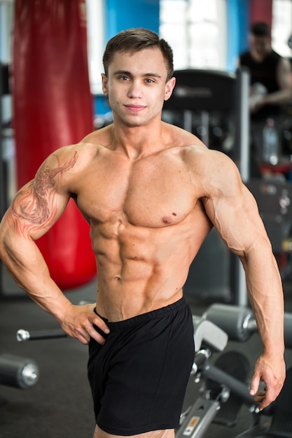 Bodybuilder posant dans la salle de gym