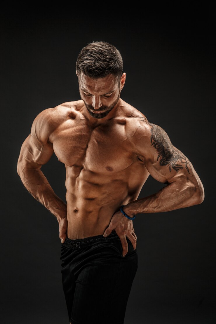 Photo bodybuilder posant. fitness musclé homme sur mur foncé.