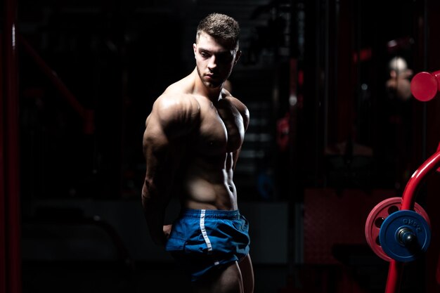 Bodybuilder sérieux debout dans la salle de gym