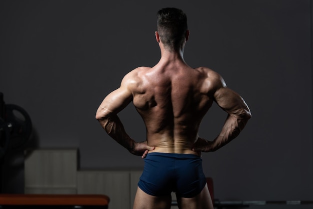 Bodybuilder sérieux debout dans la salle de gym