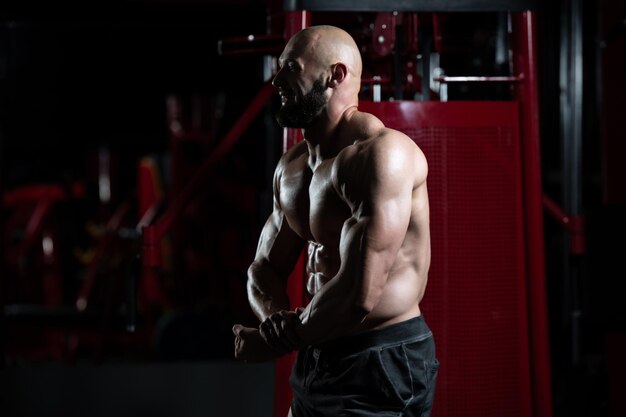 Bodybuilder sérieux debout dans la salle de gym