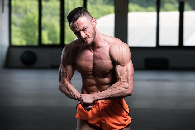 Bodybuilder sérieux debout dans la salle de gym