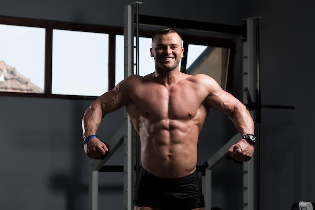 Bodybuilder sérieux debout dans la salle de gym