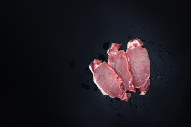 Boeuf cru avec assaisonnement sur fond sombre Filet de viande de boeuf Viande fraîche en rangée avec des épices