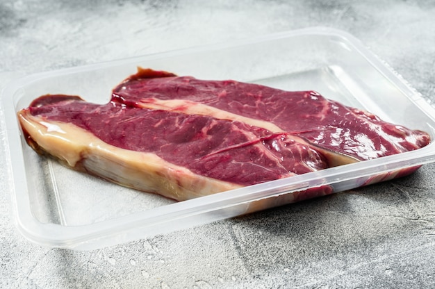 Boeuf cru frais dans un steak de New York emballé sous vide.