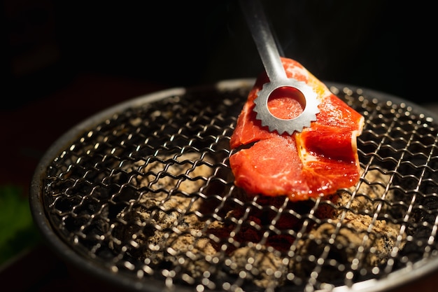 Bœuf cru sur un grillage de charbon de bois. Barbecue traditionnel coréen ou japonais