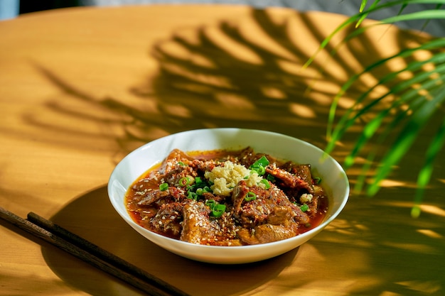 Boeuf épicé du Sichuan dans une sauce épicée, ail, poivre, graines de sésame dans un bol blanc. Cuisine chinoise. shuizhu, shui zhu