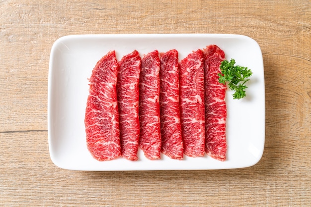 boeuf frais cru tranché avec texture marbrée servi pour Sukiyaki et Shabu ou Yakiniku