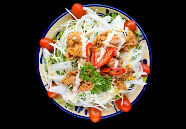 Boeuf frit vietnamien avec salade et sauce sur fond noir pour un menu