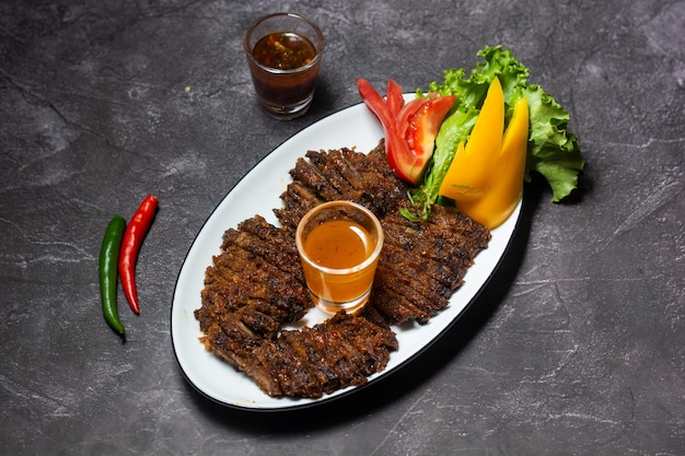 Boeuf grillé juteux coupé en tranches avec sauce servi dans un plat isolé sur fond gris vue de dessus de la nourriture indienne et bangladaise