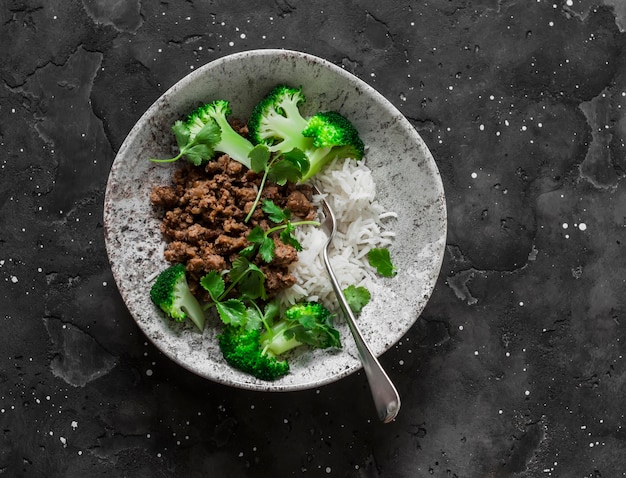 Boeuf haché riz basmati brocoli et coriandre délicieux déjeuner de style asiatique sur fond sombre vue de dessus