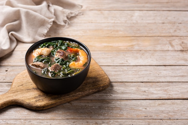 Boeuf, ragoût de gombo et soupe d'épinards dans un bol sur une table en bois