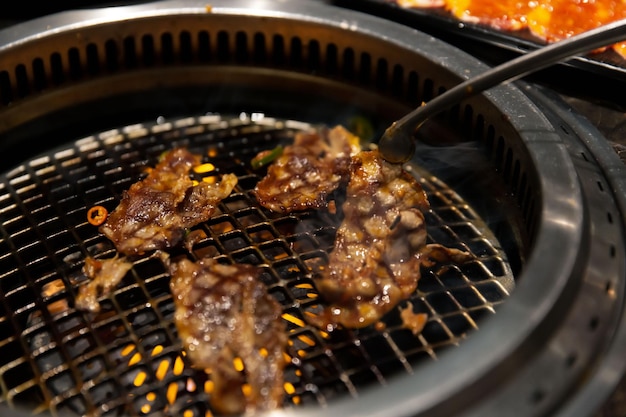 Boeuf Wagyu mariné grésillant sur l'assiette grillée dans un restaurant barbecue coréen mise au point sélective